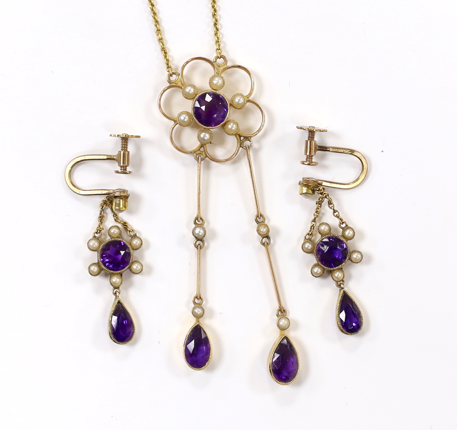 An Edwardian yellow metal, amethyst and seed pearl cluster set drop pendant necklace, 48cm and a pair if matching drop ear clips, gross weight 8.3 grams.